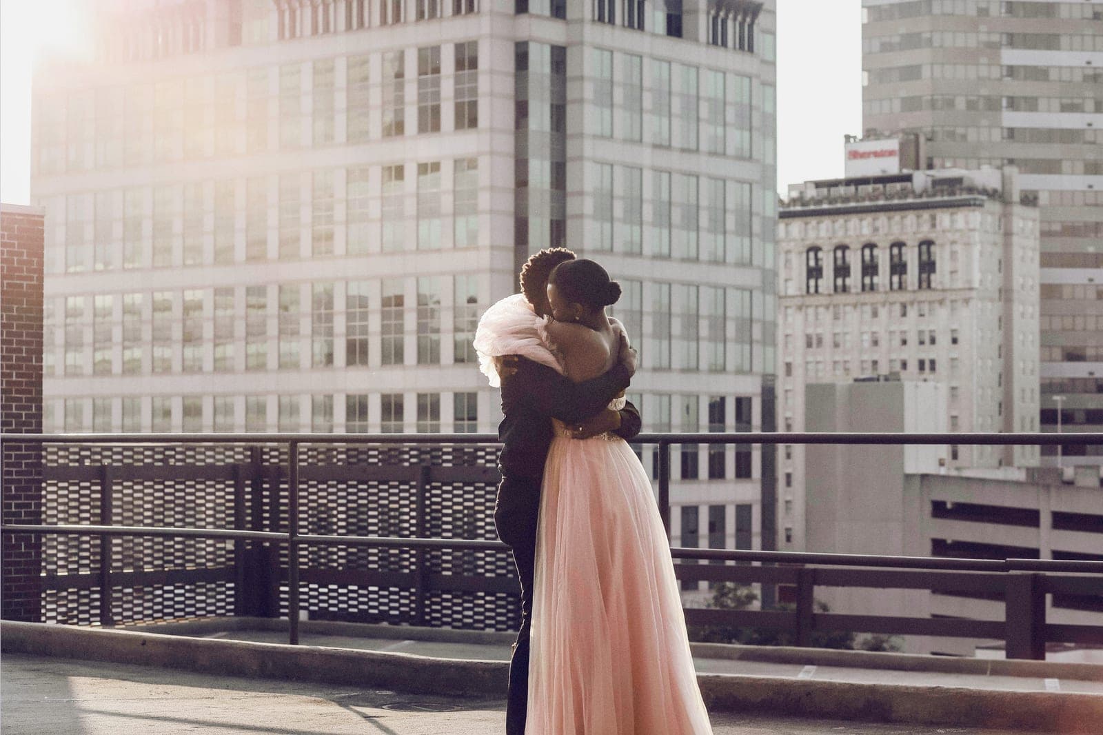 A couple embracing on a rooftop at dusk